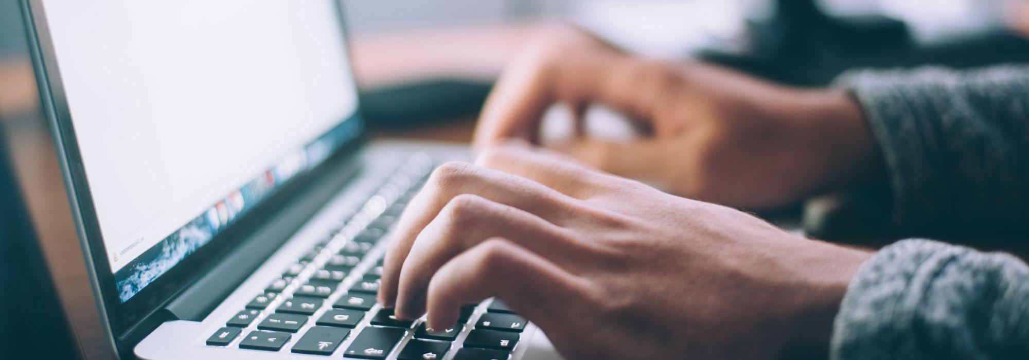 Hands typing on computer keyboard